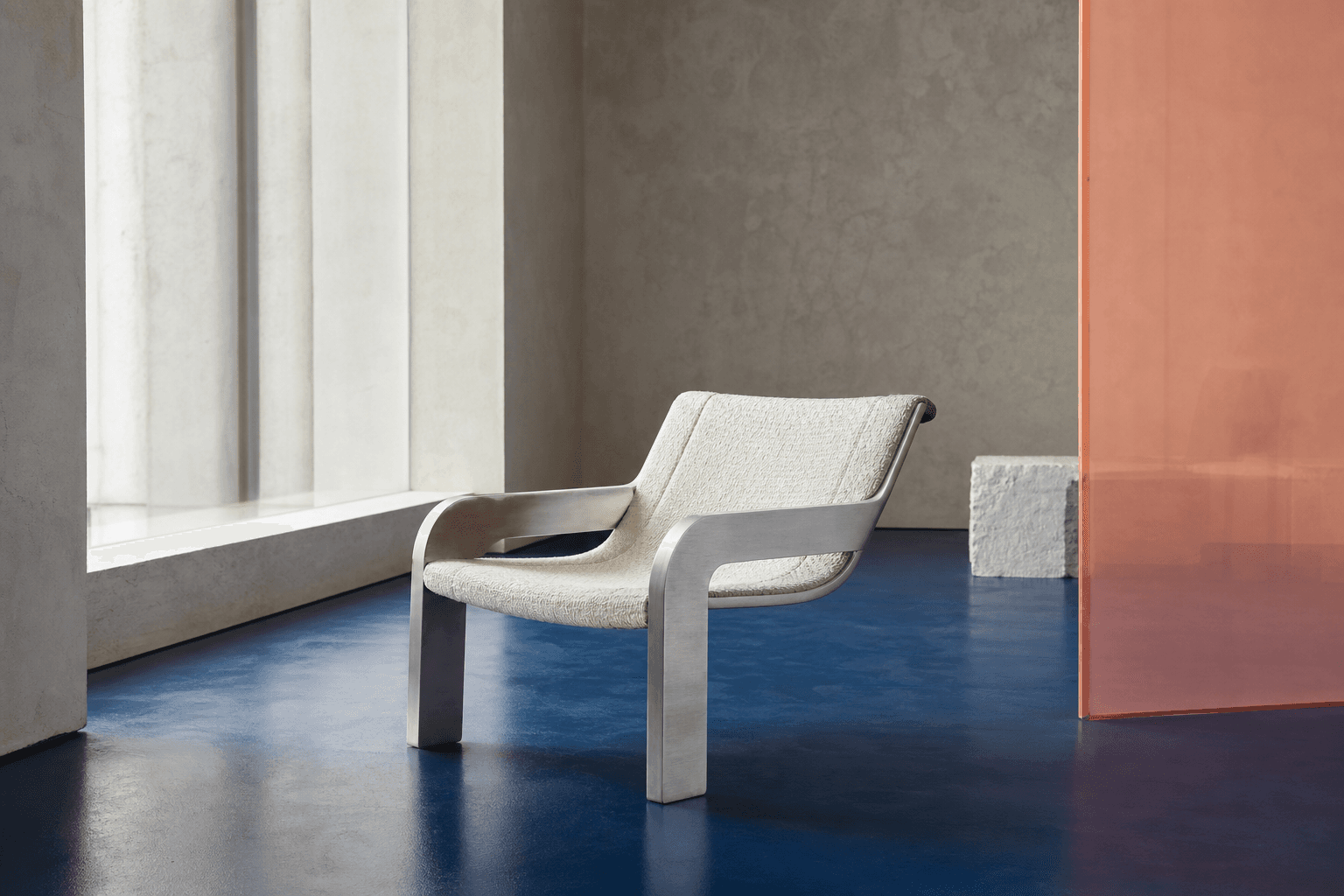 Cream lounge chair in a quiet modernist cobalt gallery